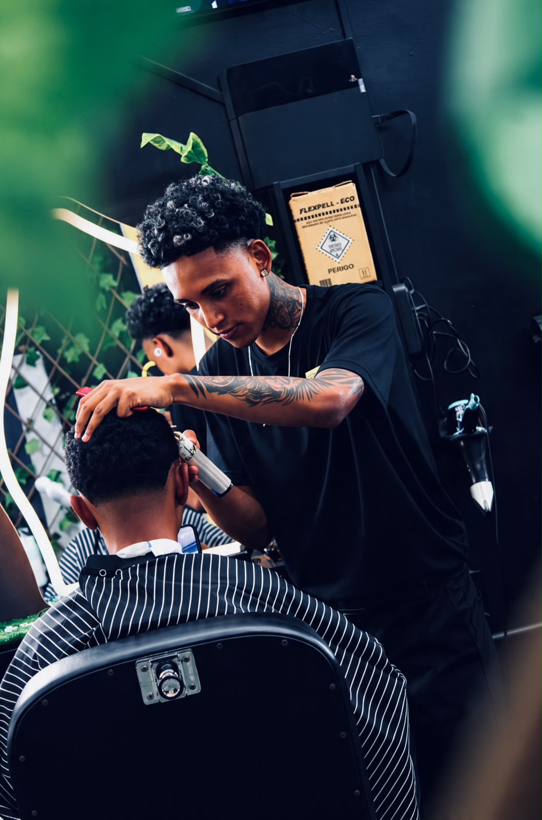 Barbeiro aparando a parte de trás do cabelo de um cliente
