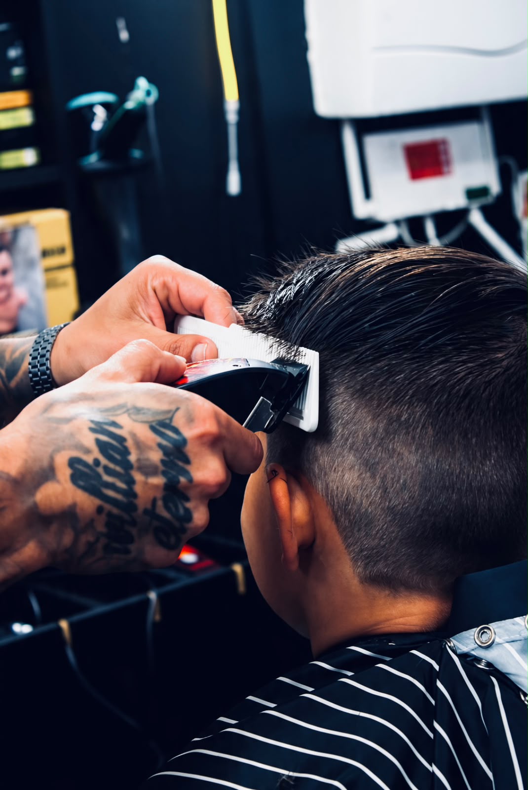 Detalhe da máquina e do pente durante um corte de cabelo